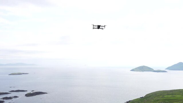 Static shot of drone flying still in mid air then moves back towards sea, Ring of Kerry