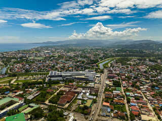 Aerial survey of Iligan City with modern and commercial buildings. Northern Mindanao, Philippines. Cityscape.