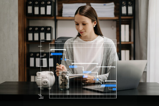 Business woman hand Project manager working and update tasks and Gantt chart scheduling virtual diagram.with smart phone, tablet and laptop in office.