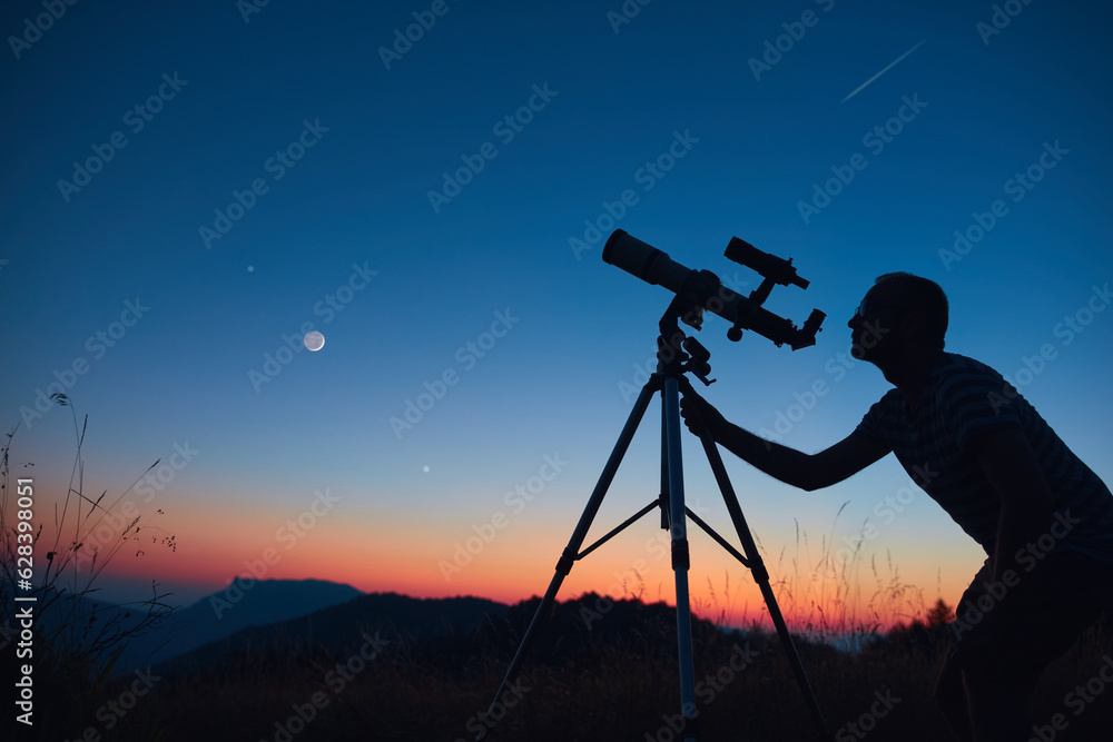 Canvas Prints astronomer looking at the starry skies and crescent moon with a telescope.