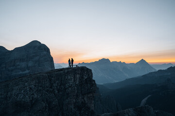 Fototapeta na wymiar Silhouette of a couple during a morning sunrise in the mountains of Italy