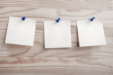 Three white paper notes mockup pinned to wooden bulletin board. sticky notes on bulletin board....