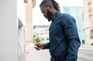 African american man retrieving money from ATM