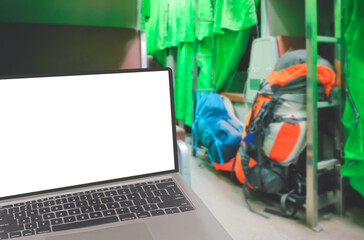 Close up of laptop with blank screen and blurred background of backpacks on aisle in sleeper train at night, png file