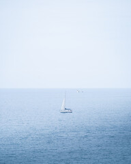 Sail boat sailing alone on the blue sea in Portugal, Algarve