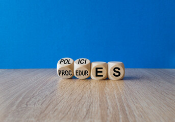 Policies vs procedures symbol. Male hand flips wooden cubes and changes the word procedures to...