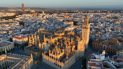Gorgeous sunrise in Seville, Spain. Aerial shot of Seville city center with gothic cathedral and famous Giralda bell tower - 628403251