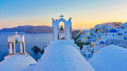 White churches an blue domes by the ocean of Oia Santorini Greece, a traditional Greek village in...