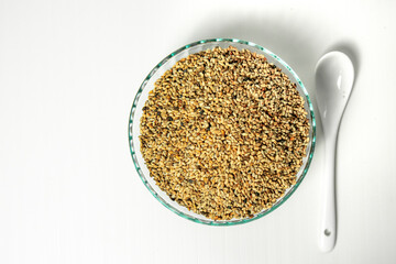 Sesame seeds in a glass bowl on a white background.