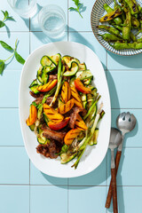 Grilled summer salad of meat and vegetables, zucchini, peaches, green onions, peppers.