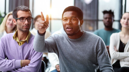 business man raise their hand at the conference to answer a question