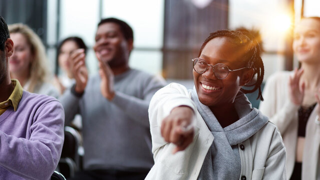 smiling african american woman pointing finger at camera.