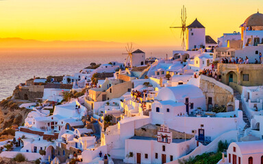 Obraz premium White churches and blue domes by the ocean of Oia Santorini Greece, a traditional Greek village in Santorini in the evening light