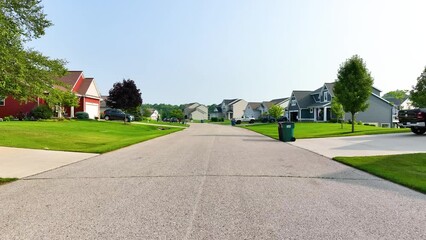 Slow pull back along the suburban street in summer.
