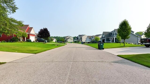 Slow pull back along the suburban street in summer.