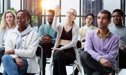 Woman raised up hands and arms in seminar class room to agree with speaker at conference seminar...