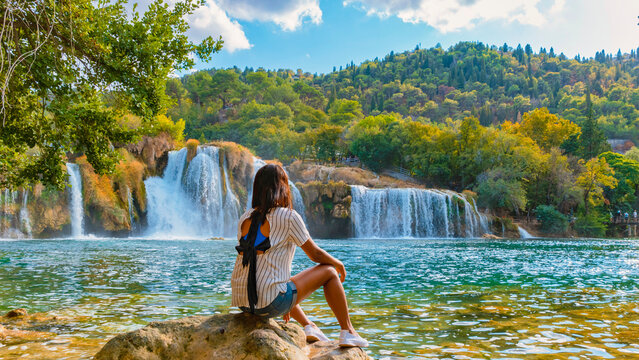 KRKA waterfalls Croatia during summer, young Asian women watch the waterfalls of krka national park Croatia on a bright summer evening in the park.
