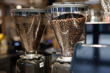 coffee beans in bean hopper, part of coffee machine in a coffee shop.