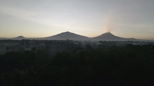 Three mountains in a row, one eruption mountain, early morning, foggy