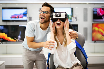 Couple enjoying with VR goggles at tech store. Shopping couple having fun at marketplace.