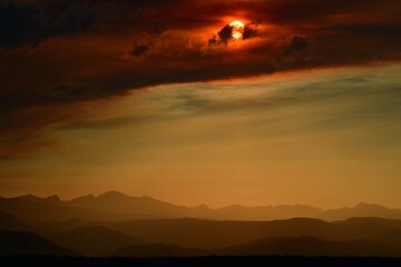 colorful sunset over the front range of the rocky mountains through the smoky haze of the spring creek wildfires near parachute, as seen from broomfield, colorado