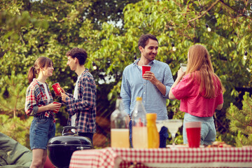 Young people, friends, couples spending good time together outdoors on warm day, doing barbecue, drinking cocktails. Concept of friendship, leisure time, weekends, summer, party, nature