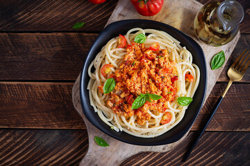 Spaghetti pasta and tomato sauce with chicken mince on a wooden background. Pasta bolognese. Top view