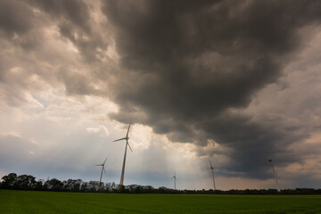 Fototapeta na wymiar dense dark rain clouds and pinwheels on a field