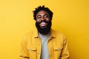 Fototapeta premium Portrait of a fictional smiling black man with a beard isolated on a plain colored background. Generative AI.