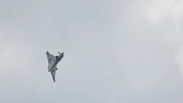 Fast Fighter Jet During High Speed Combat Maneuvers With Clouds