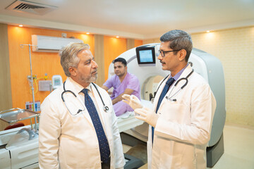 Two doctor discussing before proceeding of MRI at hospital.