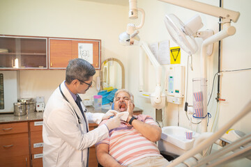 Dentist Checking patient teeth at hospital.