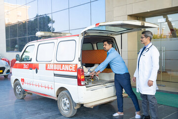 Doctor receiving old man from ambulance and checking while moaning in pain. © PRASANNAPIX