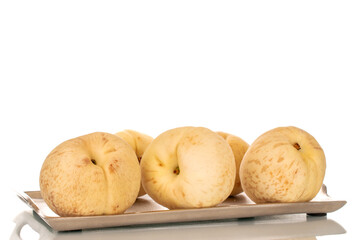 Several organic ripe peaches on a metal tray, macro, isolated on white background.