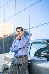 Indian man posing with his car at out of office.