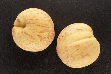 Two juicy ripe peaches on slate stone, macro, top view.