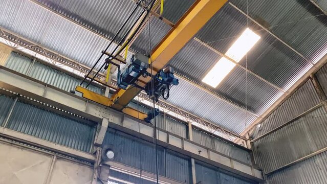 Overhead crane that moves during the transfer of goods