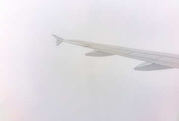 View from the airplane window at a beautiful cloudy sky and the airplane wing