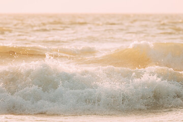 Evening sunlight sunshine above sea. Natural sunset sky warm colors. Amazing landscape scenery. Crashing waves. Sea ocean water surface with foaming small waves. Copy space. Nature background.