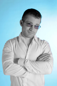 Ein kurzhaariger Mann mit Sonnenbrille im weißen Hemd verschränkt die Arme