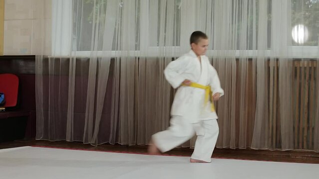 Little sportsman doing formal karate exercises