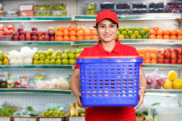 smiling Indian woman seller working at supermarket