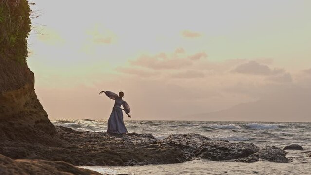 Woman Gracefully Dancing At Rocky Seashore