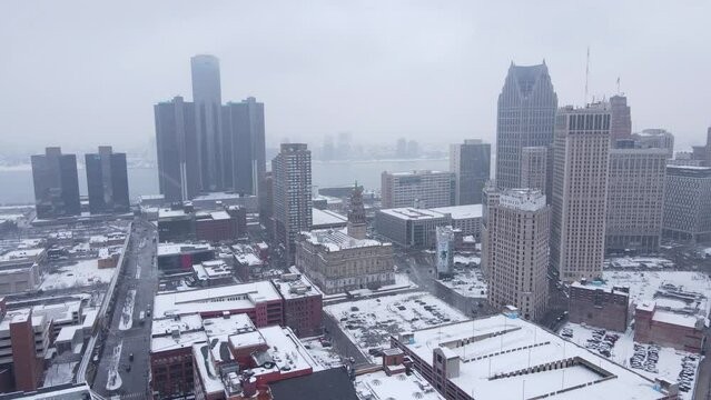 Downtown Detroit with Detroit River in background during snowfall, aerial