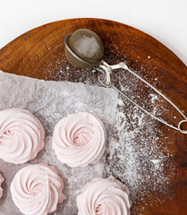 homemade marshmallow zephyr with strawberry taste on wooden boards. strawberries slice , sugar powder top view.food photography