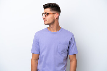 Young caucasian man isolated on white background looking to the side