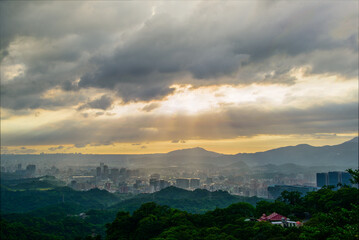 Dynamic Crepuscular Ray and silhouette of Guanyin Mountain. View of the urban landscape from Dajianshan Mountain, New Taipei City.