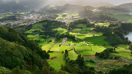 Aerial shot of green meadows, mountains and Furnas city on Sao Miguel Island, Azores, Portugal . Azores nature on sunny day 2