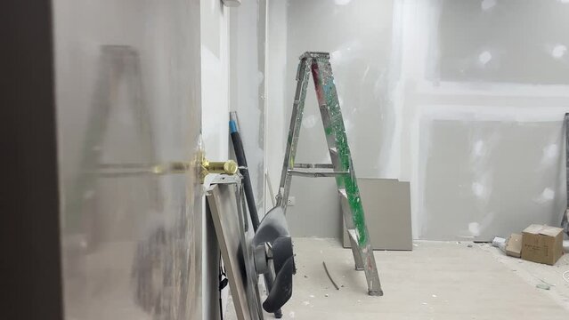 New office room interior white furniture assembly, moving in new home. Renovation works construction concept. Fan and ladder