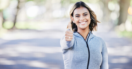 Runner woman, thumbs up and portrait in park, smile or exercise in fitness training in nature....